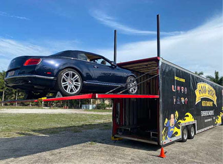 Blue car loading in the Black Good Greek Auto Transport Services Trailer